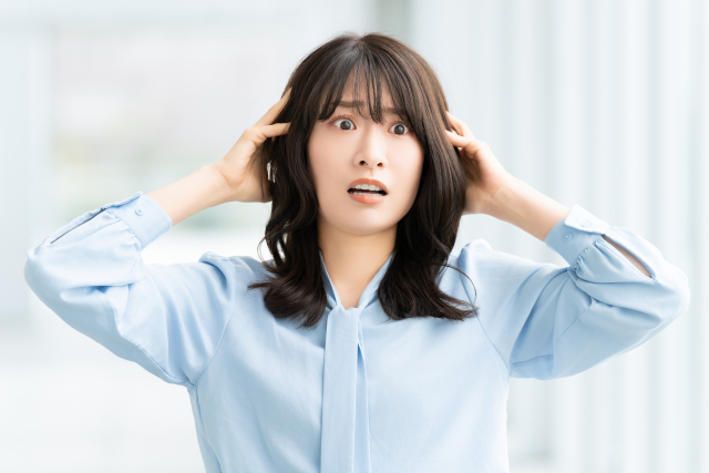 悩んで頭を抱える女性